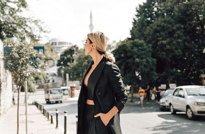 Eine Frau im Business-Outfit steht ruhig mitten auf einer Straße – Symbol für Selbstreflexion und achtsamen Umgang mit Kritik im Berufsleben.